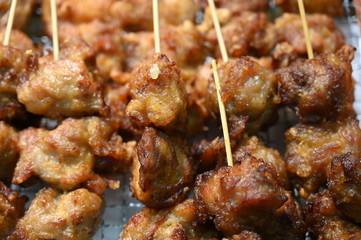 Fried fish on wooden sticks on a fish market in Osaka-Japan.