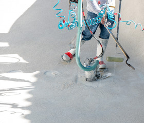 Man using a propane torch, roller, and sump pump during a swimming pool renovation.