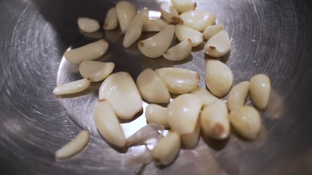 A shot of garlic inside of a metal bowl.