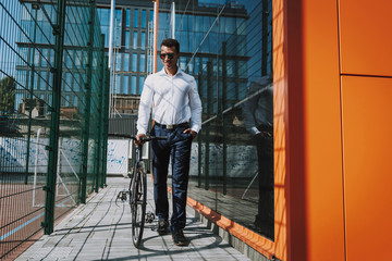 Fototapeta premium Merry man walking with bike stock photo