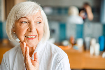 Cheerful old woman looking away and smiling