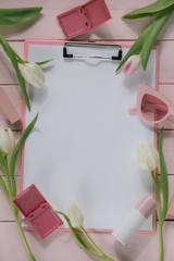 Spring mood Flat Lay. Spring To Do List.Blank blackboard, cosmetics, accessories, tulips on a pink wooden background.top view, copy space.Spring trendy background