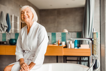 Cheerful elderly woman relaxing in spa salon