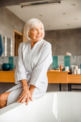 Smiling old woman resting in spa salon