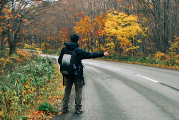 Asian man traveler enjoying autumn forest