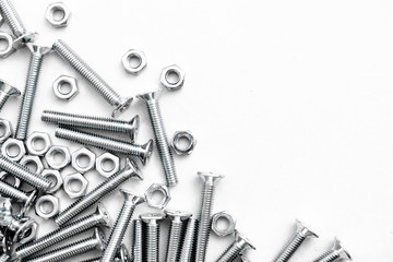 Top view of stainless steel bolts or iron nails on brigth white background with silver color. Metal screws for use in sheet metal. - obrazy, fototapety, plakaty