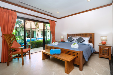 Spacious bedroom with blue bedsheet and woodden wadrobe