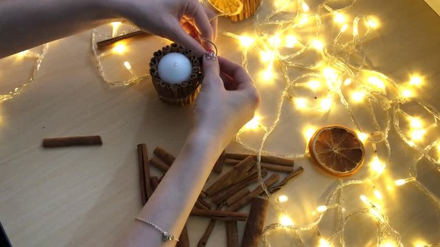 Candle decoration with cinnamon sticks, twine and dried orange