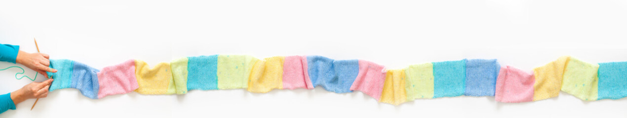 Knitted long scarf in pastel colors. Unicorn style. White background.