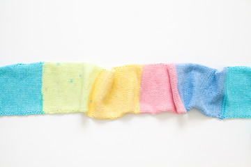 Knitted long scarf in pastel colors. Unicorn style. White background.