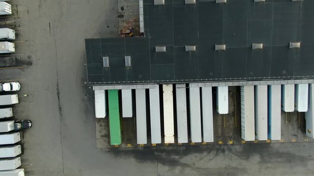 Top down aerial of cargo trailers lined up a distribution center in United States, cargo, shipping, transportation, logistics concept