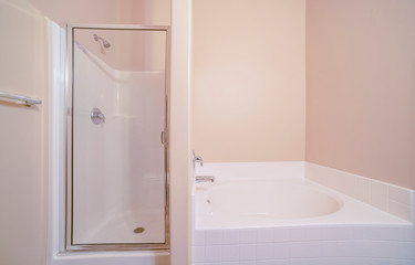 Shower cabin and bathtub in bathroom in home