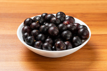 Detail of fruit in bowl with water droplets. Jaboticaba or Jabuticaba is the native Brazilian grape tree. Species Plinia Cauliflora. Brazilian Berry.