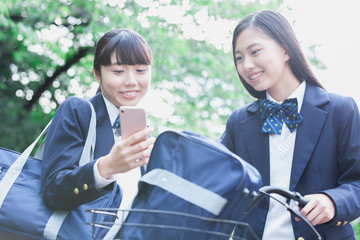 スマートフォンを見せる女子学生