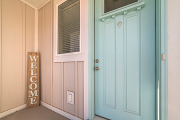 Green wooden front door with welcome sign