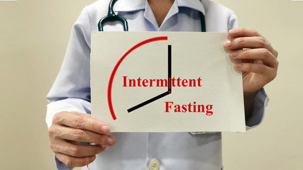 Doctor show Intermittent fasting. Intermittent energy restriction is meal timing schedules cycle between voluntary(reduced calories intake)and non-fasting over given period. Medical health concept