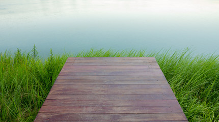 wooden planks background with green grass on river