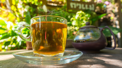 Hot tea cup top on wooden with coffee shop in the garden.