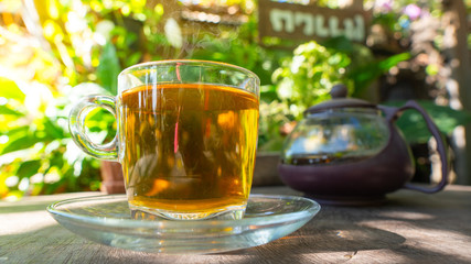Hot tea cup top on wooden with coffee shop in the garden.