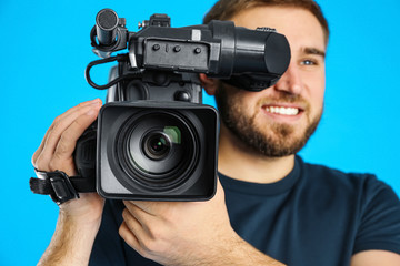 Obraz premium Operator with professional video camera on blue background