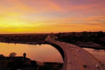 Aerial view during twilight over Pacific Coast Highway or PCH in Newport Beach with cars crossing...