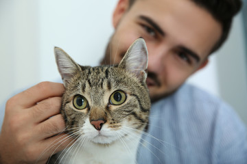 Happy man with cat at home. Friendly pet