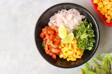 Food vegetable salad with corn and onions, tomatoes, coriander, lemons. healthy green meal. Indian Corn Masala chaat. Recipe ingredients with copy space,