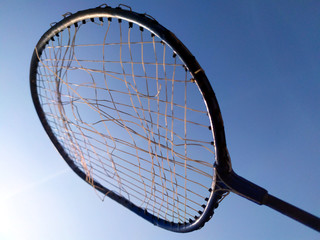 a broken wire racket whit light blue background