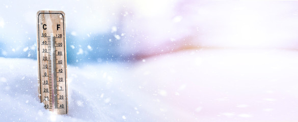 Winter time. thermometer on snow shows low temperatures.