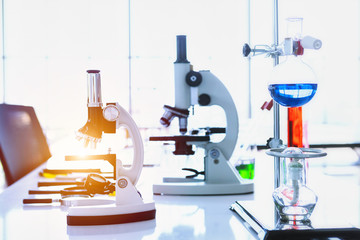 Microscope and test tubes with lab glassware in laboratory background, research and Scientific concept