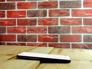 A white screen smartphone placed on a wooden office desk