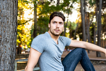 Young handsome model posing careless in a park