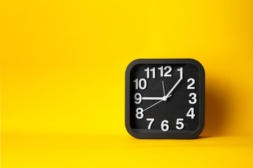 black and white clock time face on yellow background