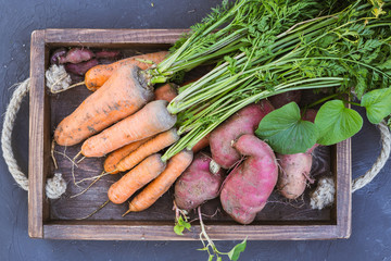 Sweet potato and carrots in a wooden box.