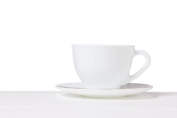 White Cup and saucer on a white table isolated on a white background.
