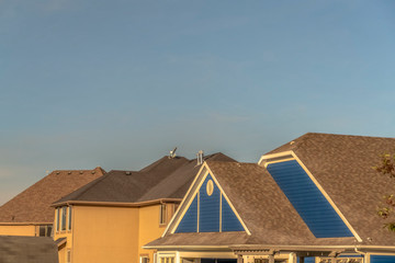 Dark color roof of houses viewed against cloudless blue sky on a sunny day