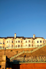 Fototapeta premium A Typical Brighton Georgian houses on the seafront a staircase in a big brick wall leading to the beach, Brighton, Sussex, UK. a big blue sky, ideal copy space