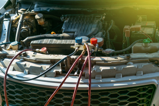 technician checking air conditioner in engine room of eco car , cleaning air conditioner of car 