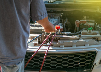 technician checking air conditioner in engine room of eco car , cleaning air conditioner of car 