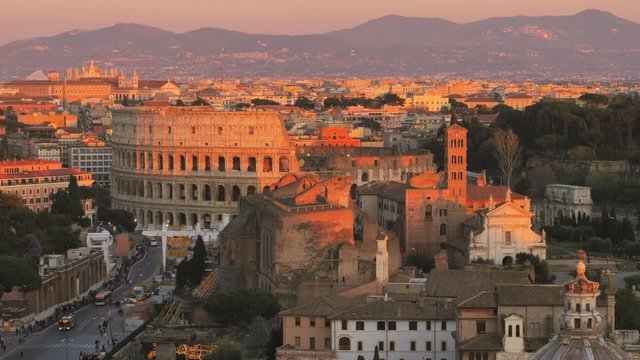 Rome city center establishing shot of colosseum at sunset aerial view zoom out