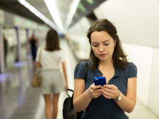 Obraz na płótnie Canvas Female with phone waiting for subway train