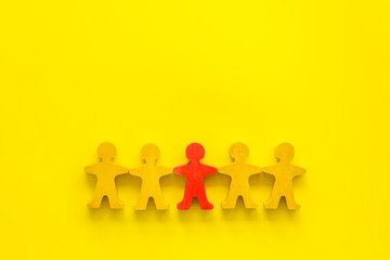 Leadership concept. People cutuots - red figure against others on yellow background top-down copy...
