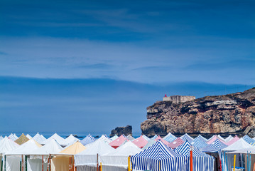 Fototapeta na wymiar cliff and beach tents in Nazare, Portugal