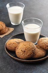 Chocolate chip cookies with milk on black table. Copy space.