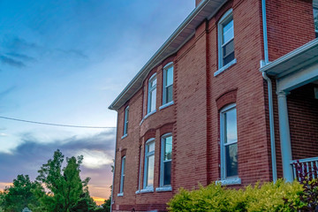 Exterior of home with red brick wall and sliding windows reflecting the skyscape