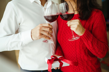Hands holding glasses of wine on restaurant background. Couple clink glasses with red wine. Romance at restaurant for Valentine's Day- concept. Relationship & Birthday concept.