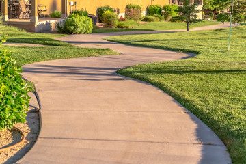 Fototapeta premium Close up of narrow paved pathway winding through lush grasses on a sunny day