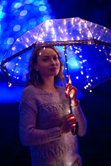 Girl with an umbrella in the night city with lights.Art photo