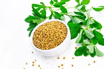 Fenugreek with green leaves in bowl on light board
