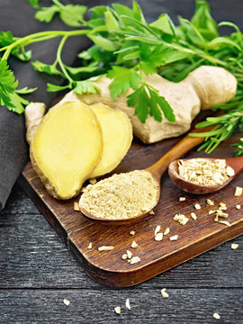 Ginger ground and flakes in spoons on wooden board